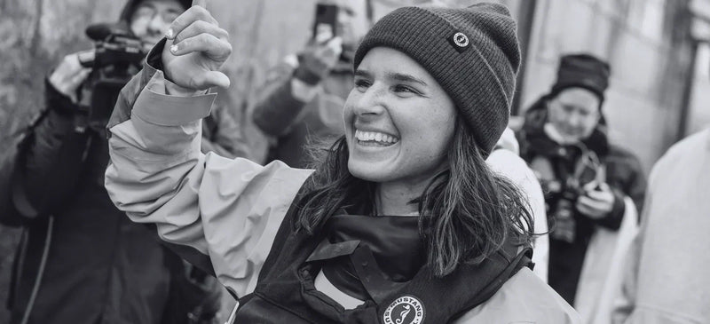 Victorious ambassador smiling on deck after a win, dressed in Mustang Survival gear maintained for lasting waterproof performance.